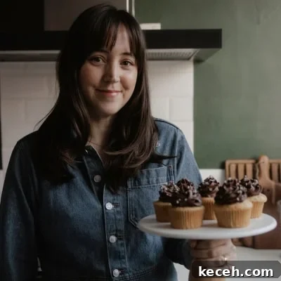 Moist Banana Coffee Cake with Sour Cream Glaze 16 Ella from Alpine Ella is holding a cake stand with cupcakes on it.