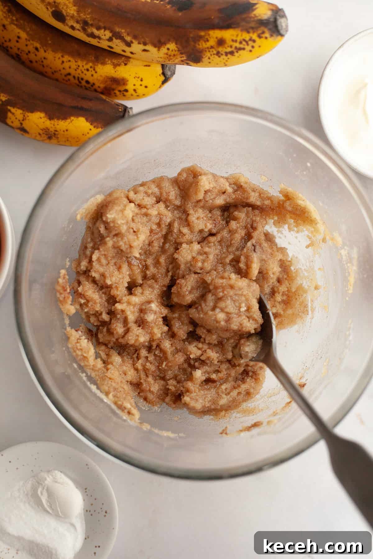 Moist Banana Coffee Cake with Sour Cream Glaze 5 A glass bowl with a spoon and streusel topping in it.