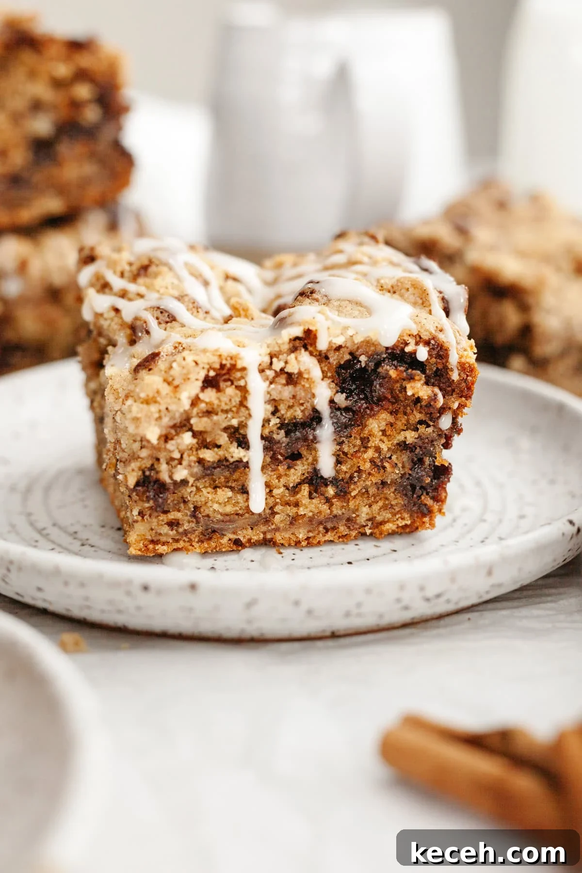 Moist Banana Coffee Cake with Sour Cream Glaze 10 A slice of banana bread coffee cake drizzled with a white glaze on a small plate.