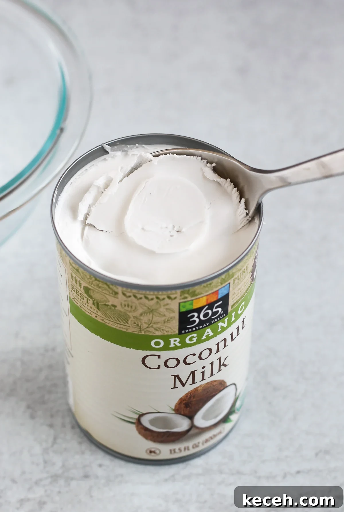 Coconut Whipped Cream Recipe: Light, Dairy-Free Topping 3 close up coconut milk can with the coconut cream being scooped out