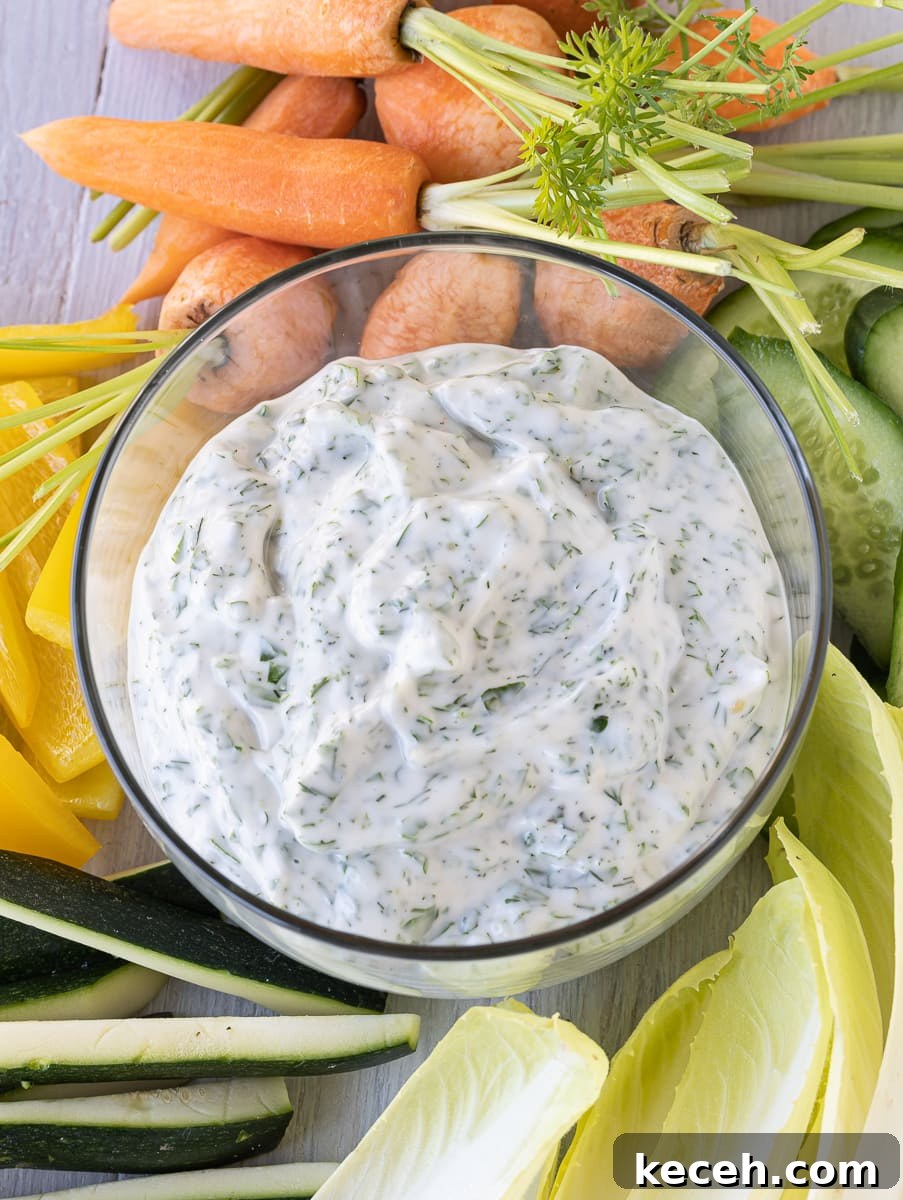 Creamy Green Goddess Dressing & Herb Dip Recipe 5 Creamy green goddess dip flecked with lots of green herbs surrounded by raw vegetables for dipping.