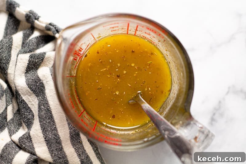 Overhead shot of a measuring cup filled with homemade vinaigrette dressing