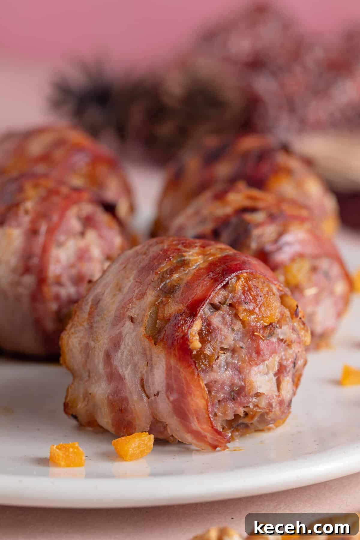 Close up of a plate of bacon-wrapped gluten free stuffing balls with chopped apricots.