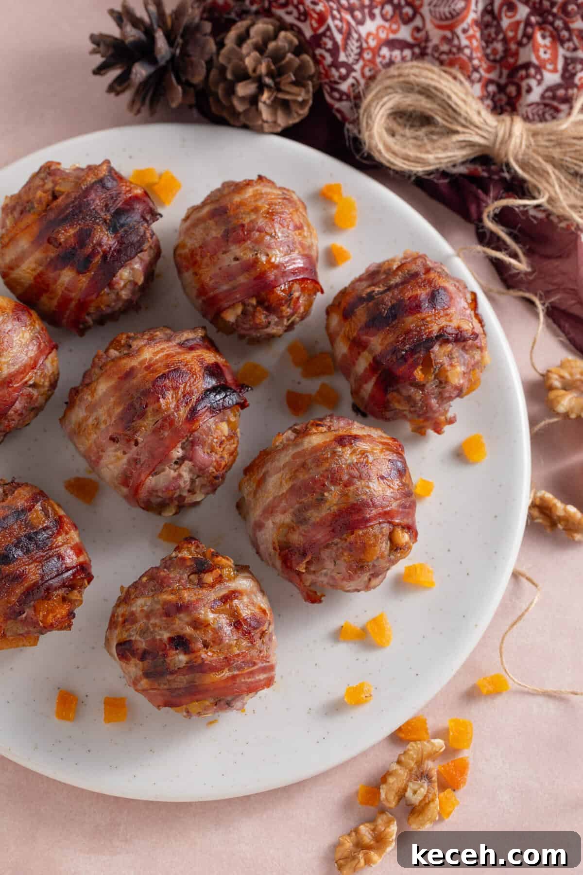 A plate of bacon-wrapped gluten free stuffing balls with chopped apricots.