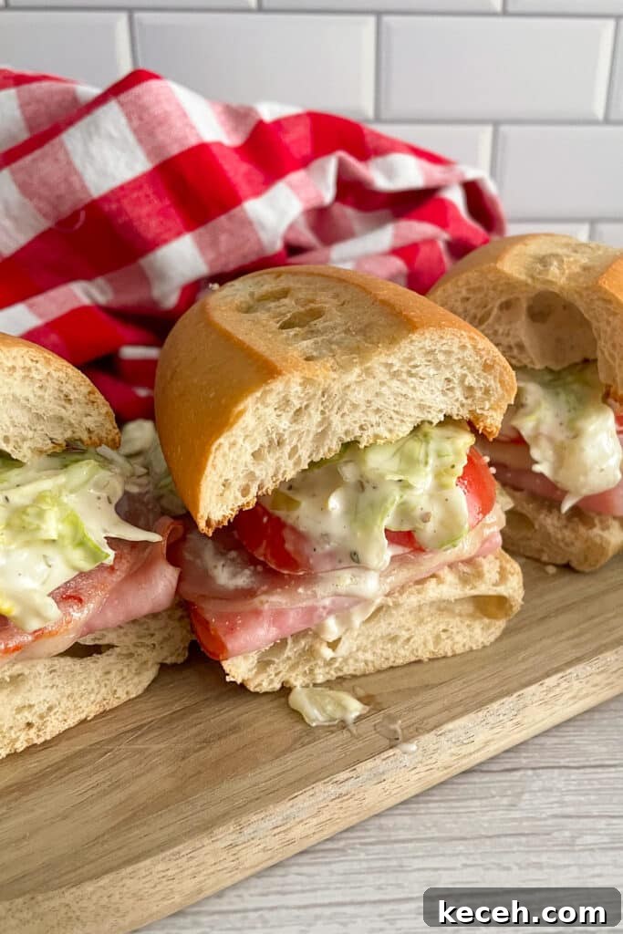 Italian Deli-Style Grinder Sandwich Recipe (Copycat) 4 Copycat Grinders Italian sandwich placed on a wooden plate ready to serve