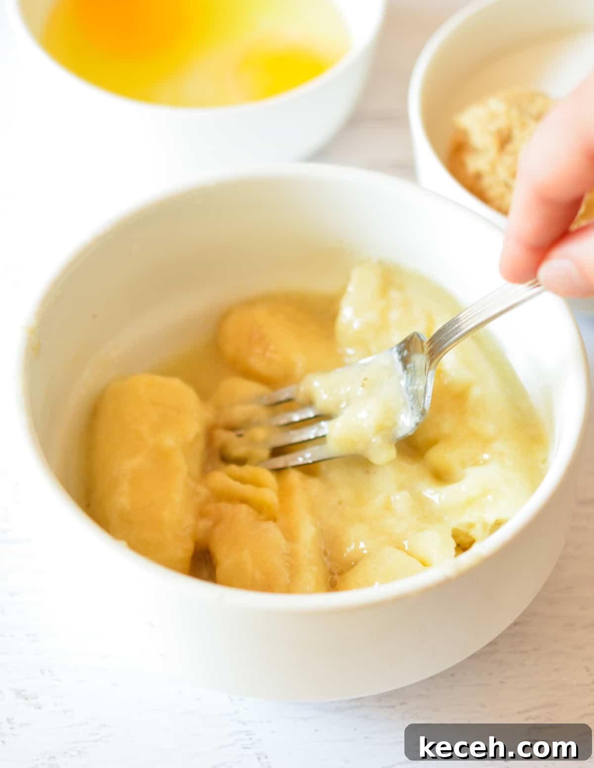 Moist Banana Bread Made with Frozen Bananas 6 a fork mashing bananas.