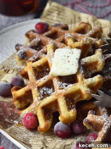 Close-up of eggnog waffles on a platter with cranberries around it.