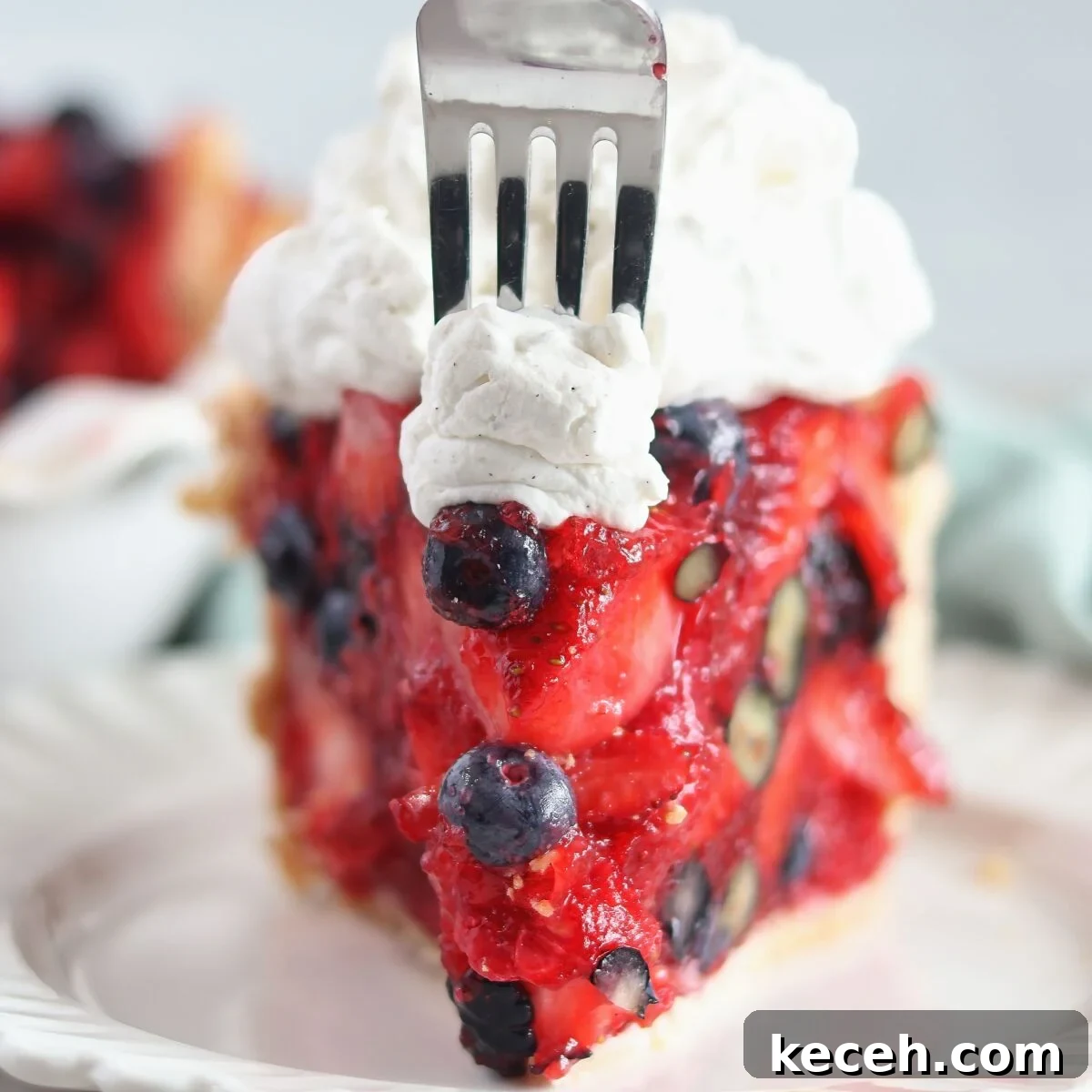 Gluten-Free Mixed Berry Pie Recipe — Fresh Summer Dessert 11 fork cutting into slice of pie and whipped cream at the point.
