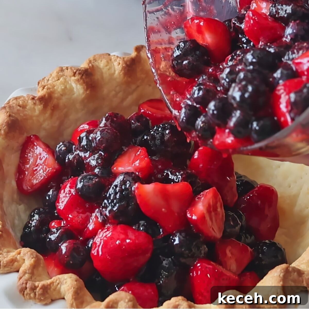 Gluten-Free Mixed Berry Pie Recipe — Fresh Summer Dessert 9 pouring berry filling into baked pie shell.
