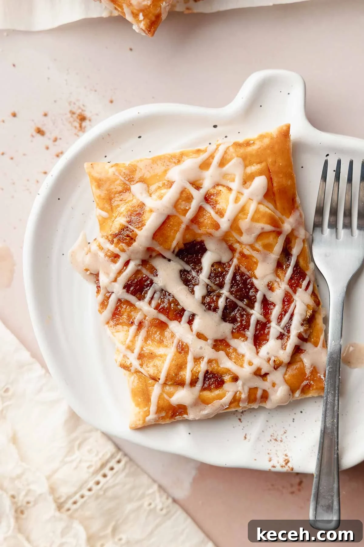 Gluten-Free Pumpkin Cream Cheese Danish Recipe — Starbucks Copycat 2 Gluten-free pumpkin danish served on a white plate with a fork. The pastry has a crisp, golden edge and a spiced pumpkin filling with icing drizzled on top.