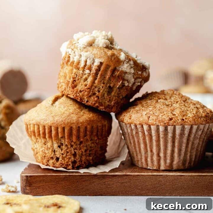 Gluten free sourdough discard banana muffins stacked on top and next to each other. One has streusel topping.