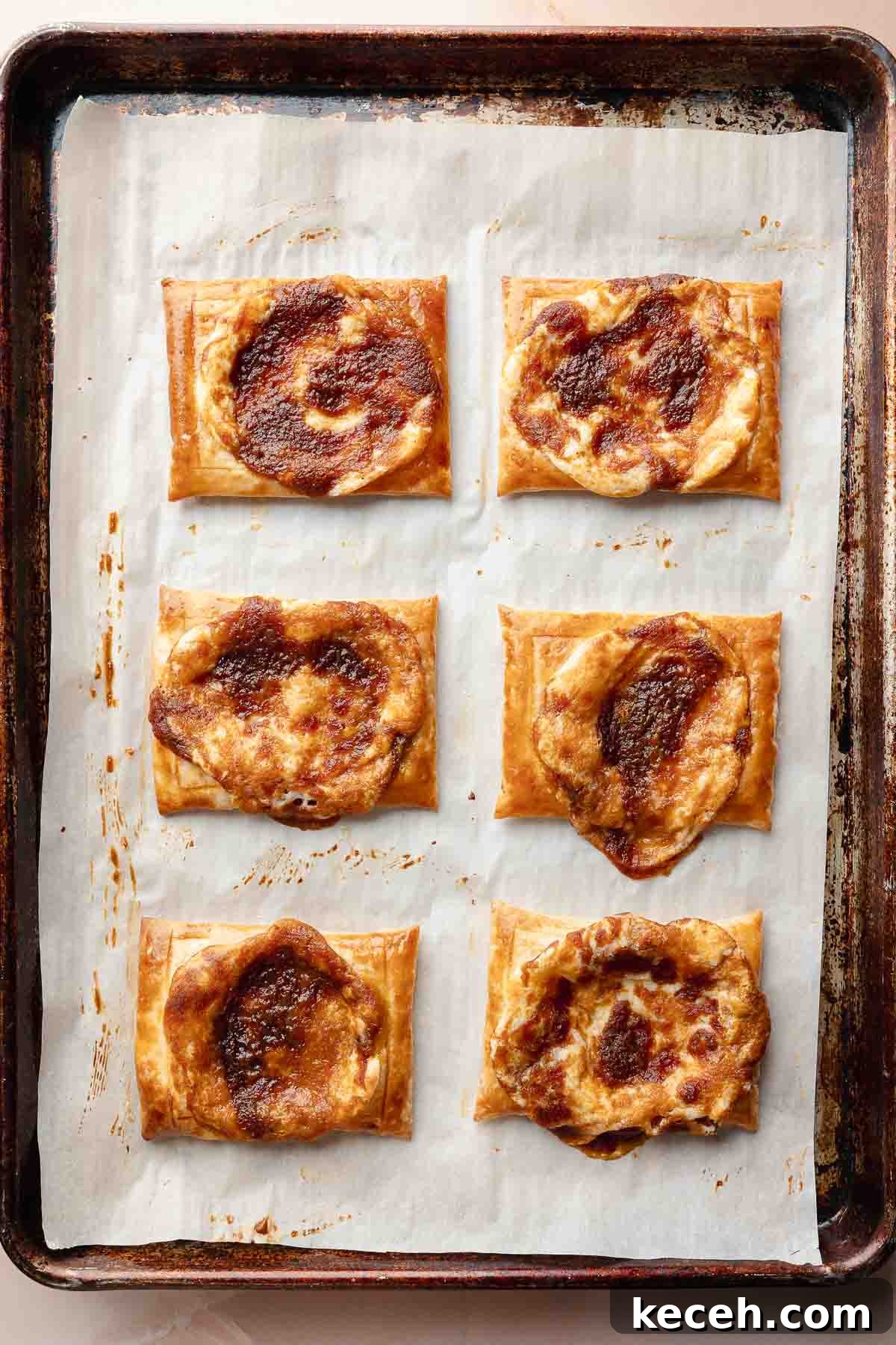 Gluten-Free Pumpkin Cream Cheese Danish Recipe — Starbucks Copycat 8 Baked pumpkin danishes on the tray. The pastries are golden and puffed with caramelized, spiced filling in the center.