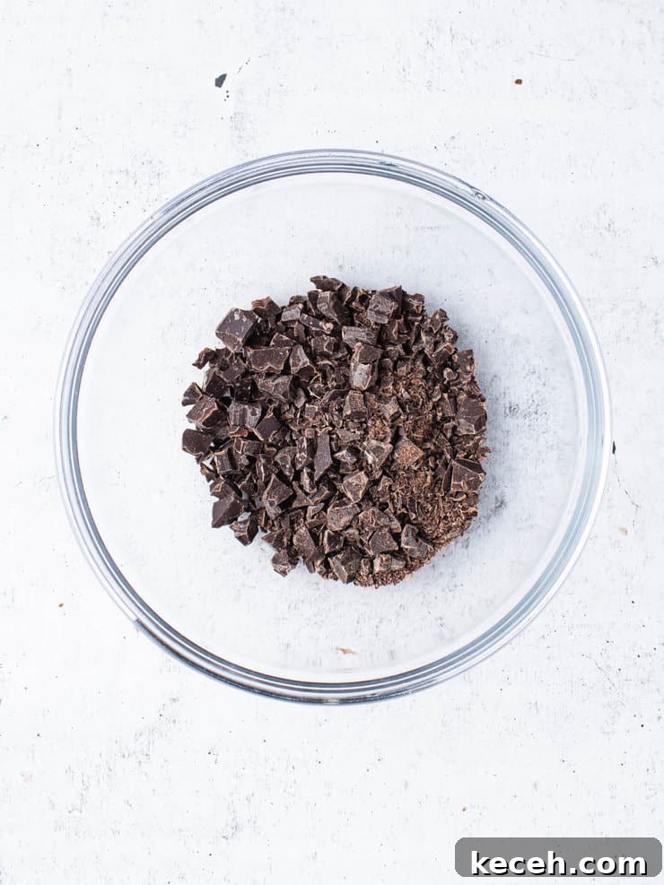Chocolate Ganache Recipe: Smooth, Glossy Ganache in Minutes 4 Finely chopped up chocolate in a clear bowl.