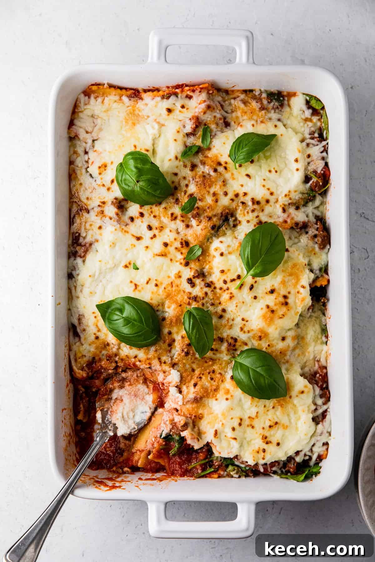 spinach ricotta ravioli dish with baked ravioli and basil leaves