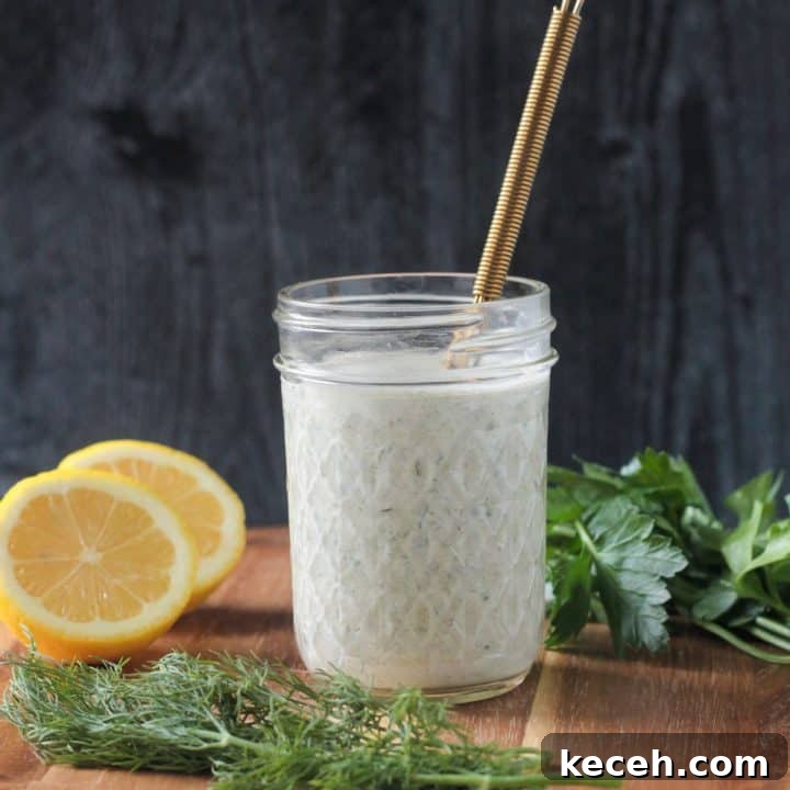Creamy white hemp seed dressing in a jar with a gold whisk.