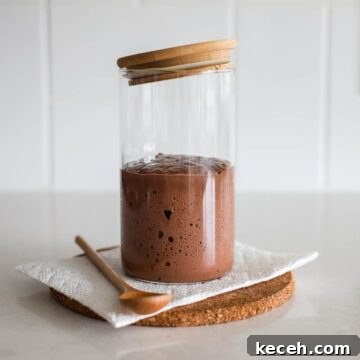 Sourdough Chocolate Starter: How to Make It and What to Use It For 7 Chocolate sourdough starter in a jar with spoon.