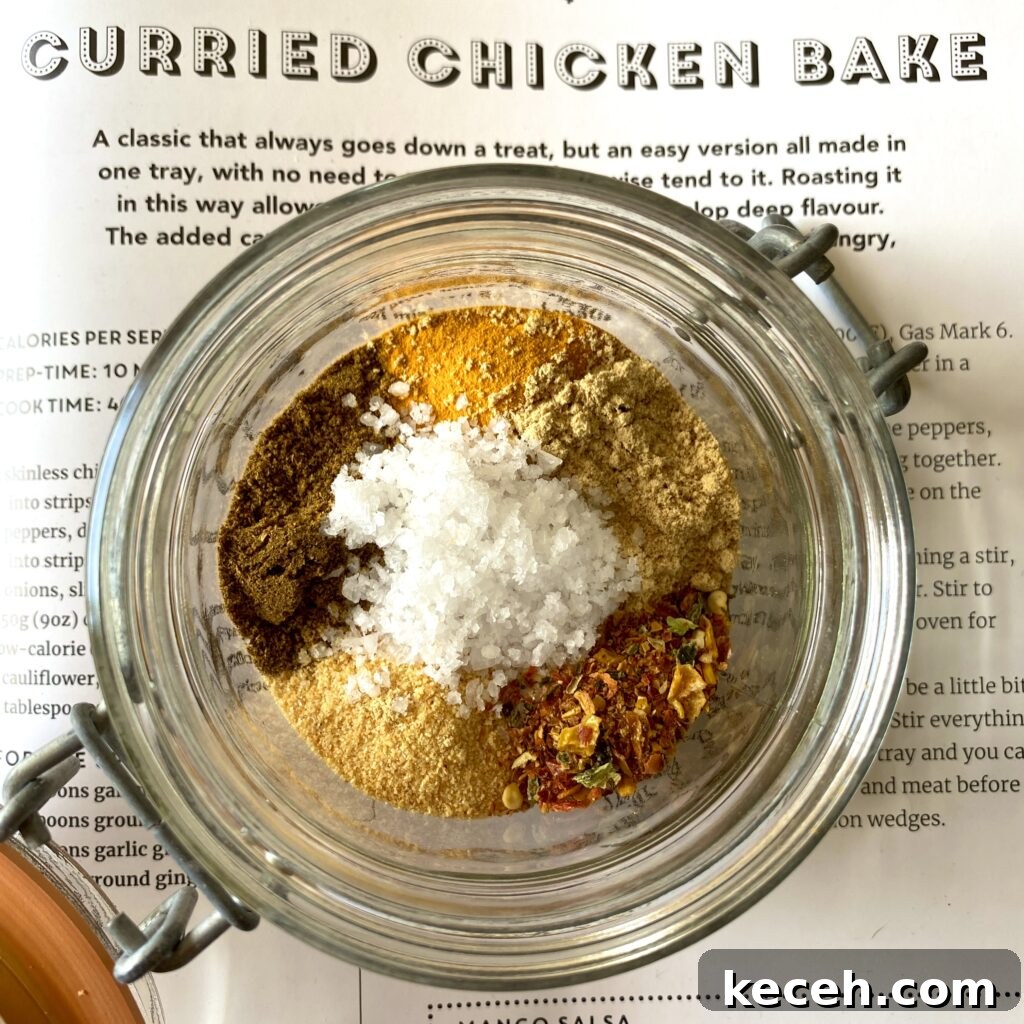 Curried Chicken Tray Bake Recipe from The Slimming Foodie 12 Small glass jar of mixed curry spices on the page of a cookbook showing the recipe