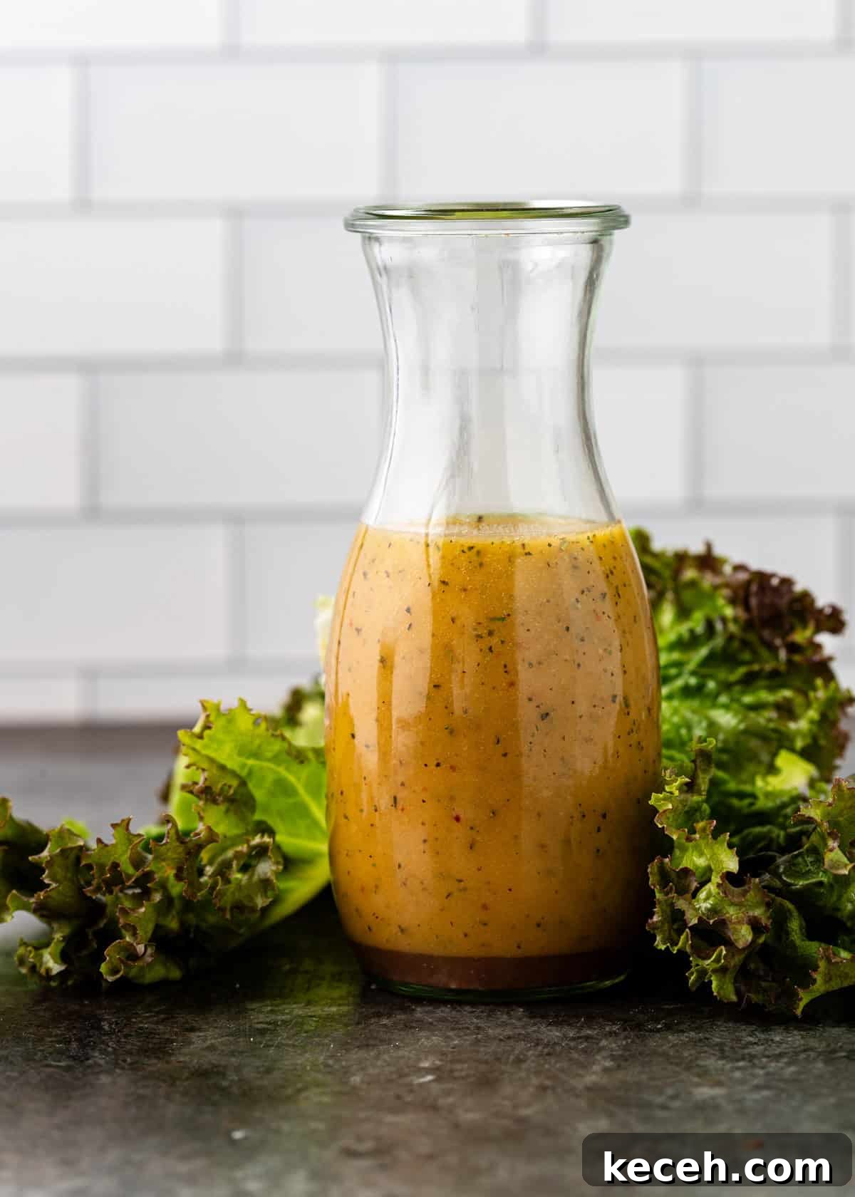 Two Homemade Italian Salad Dressings: Classic & Zesty Variations 10 side view: italian dressing in a glass jar with lettuce surrounding the base