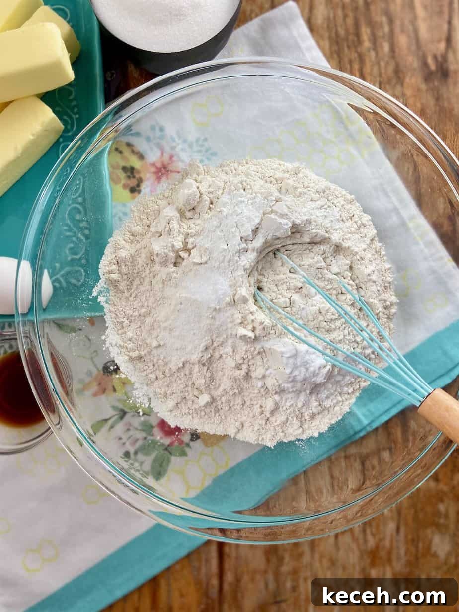 Perfect Cookie Dough Recipe for Baking and Safe Snacking 4 Cookie dough ingredients, Flour, baking powder, baking soda and salt in clear mixing bowl.