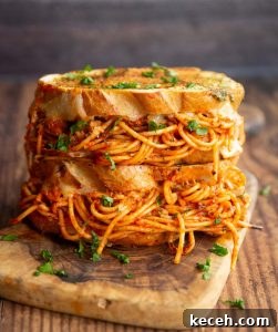Spaghetti Sandwich two spaghetti sandwiches stacked on each other on chopping board garnished with parsley