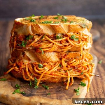 two spaghetti sandwiches stacked on each other on chopping board garnished with parsley