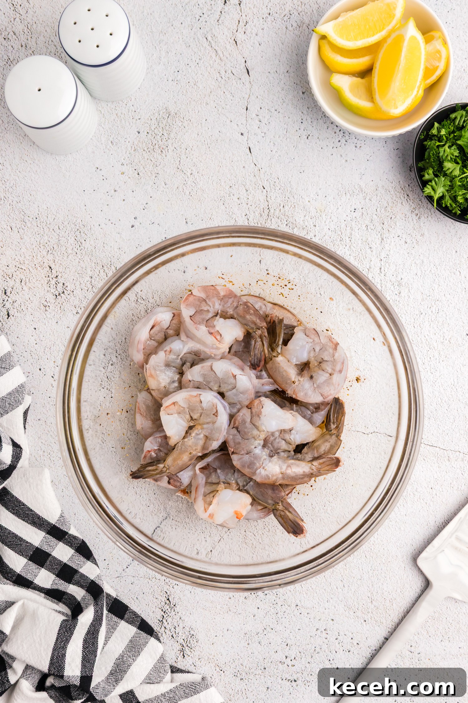 Crispy Blackstone Grilled Shrimp with Garlic Butter Sauce 7 Raw shrimp added to a bowl with marinade at the bottom, about to be mixed.