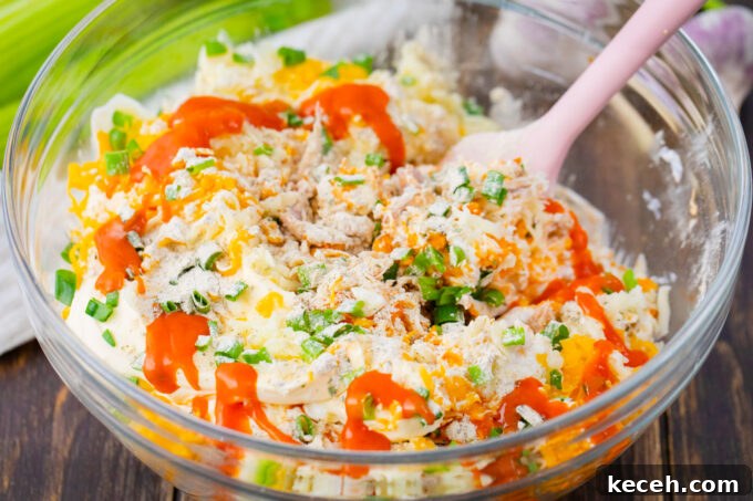 One-Bowl Buffalo Chicken Dip Recipe for Game Day 5 Stirring Buffalo crack chicken dip ingredients in a bowl.