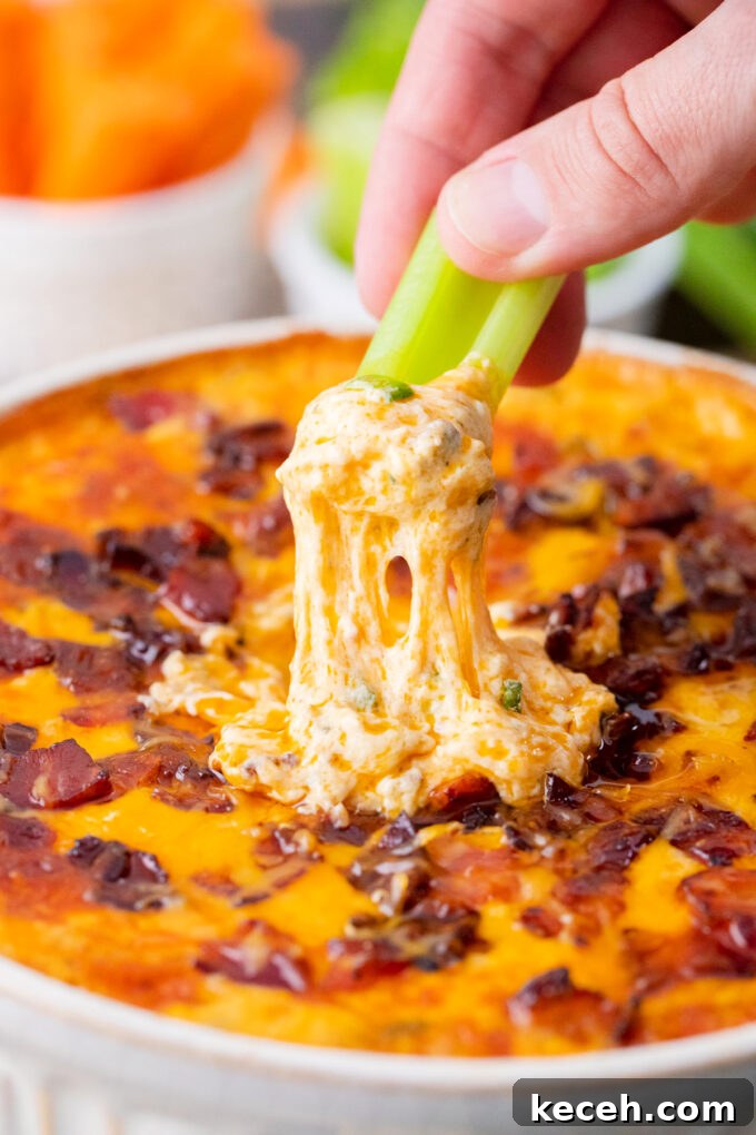 One-Bowl Buffalo Chicken Dip Recipe for Game Day 9 Dipping a celery stick into Buffalo crack chicken dip.