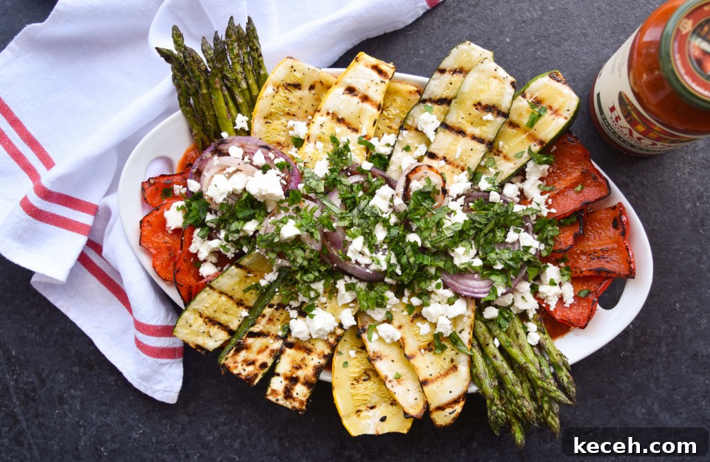 Grilled Vegetables with Tomato-Basil Sauce, Feta & Fresh Herbs 5 Overhead view of a platter of grilled vegetables on top of a red and white dish cloth.