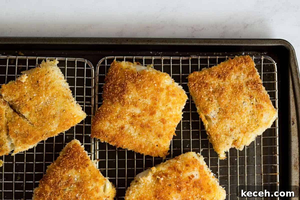 Crispy Oven-Baked Fish Sandwiches You’ll Crave 7 Crispy pan-fried fish draining on a wire rack to maintain crunchy exterior