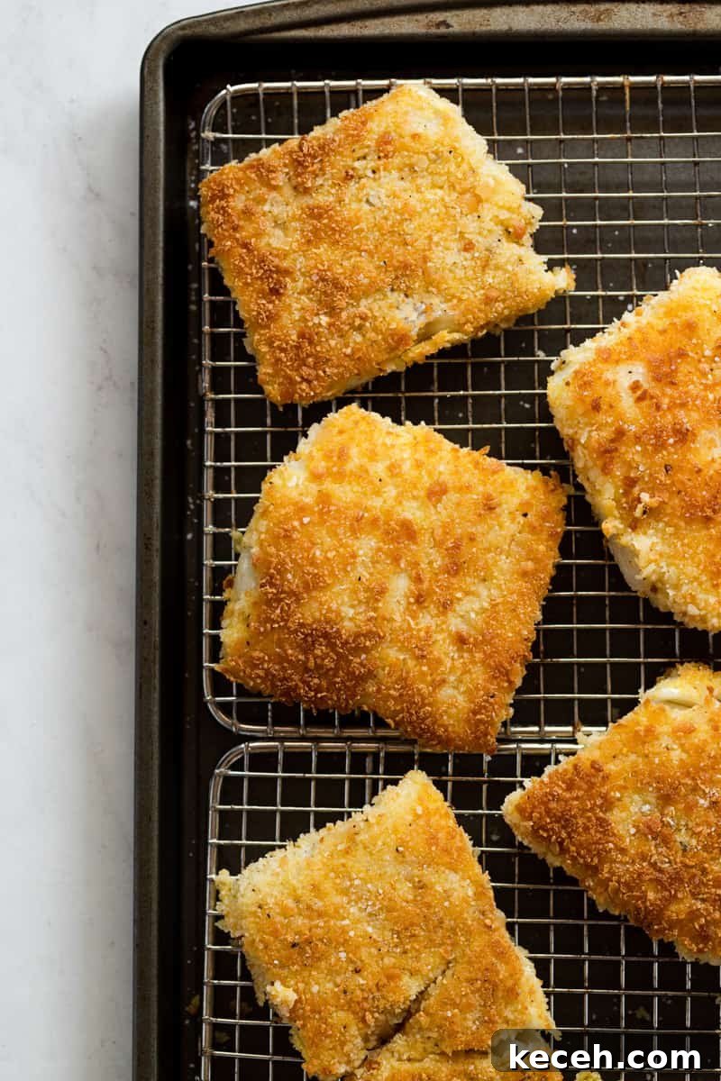 Crispy Oven-Baked Fish Sandwiches You’ll Crave 8 Crispy pan-fried fish draining on a wire rack to maintain crunchy exterior