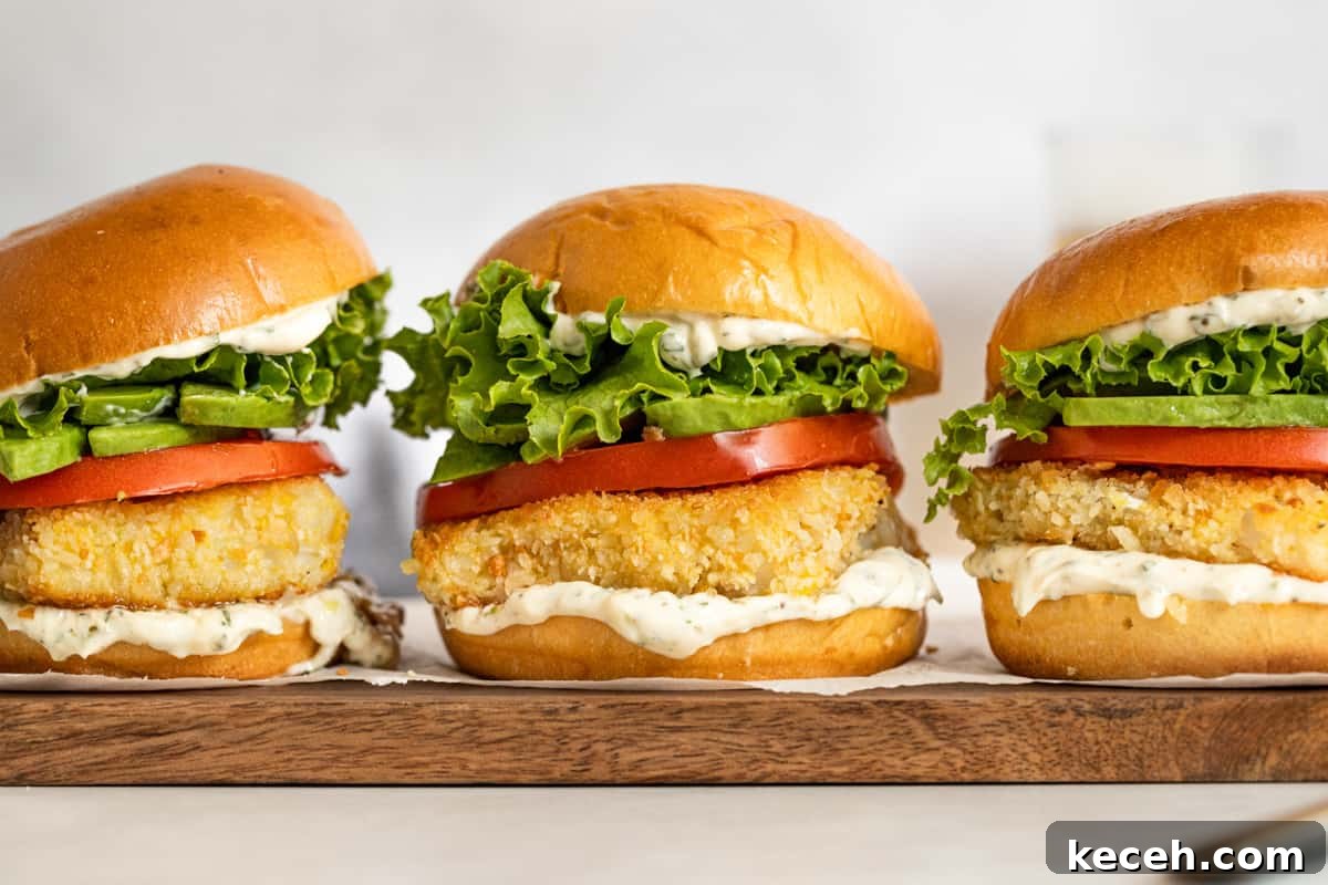 Crispy Oven-Baked Fish Sandwiches You’ll Crave 9 Crispy fish sandwiches with tarragon aioli, lettuce, and tomato on a wooden board