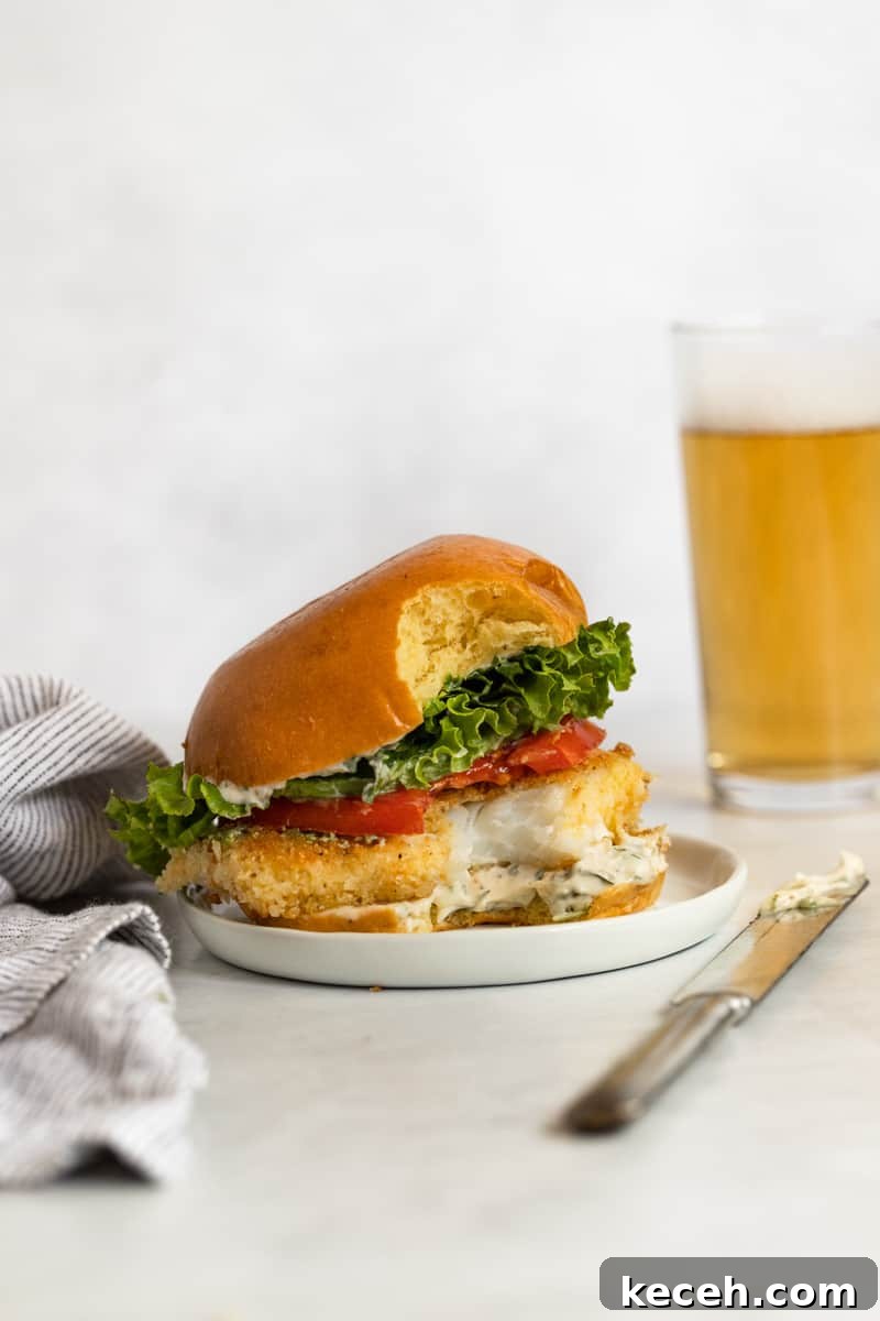 Crispy Oven-Baked Fish Sandwiches You’ll Crave 10 Half-eaten crispy fish sandwich with golden crust, lettuce, and creamy aioli