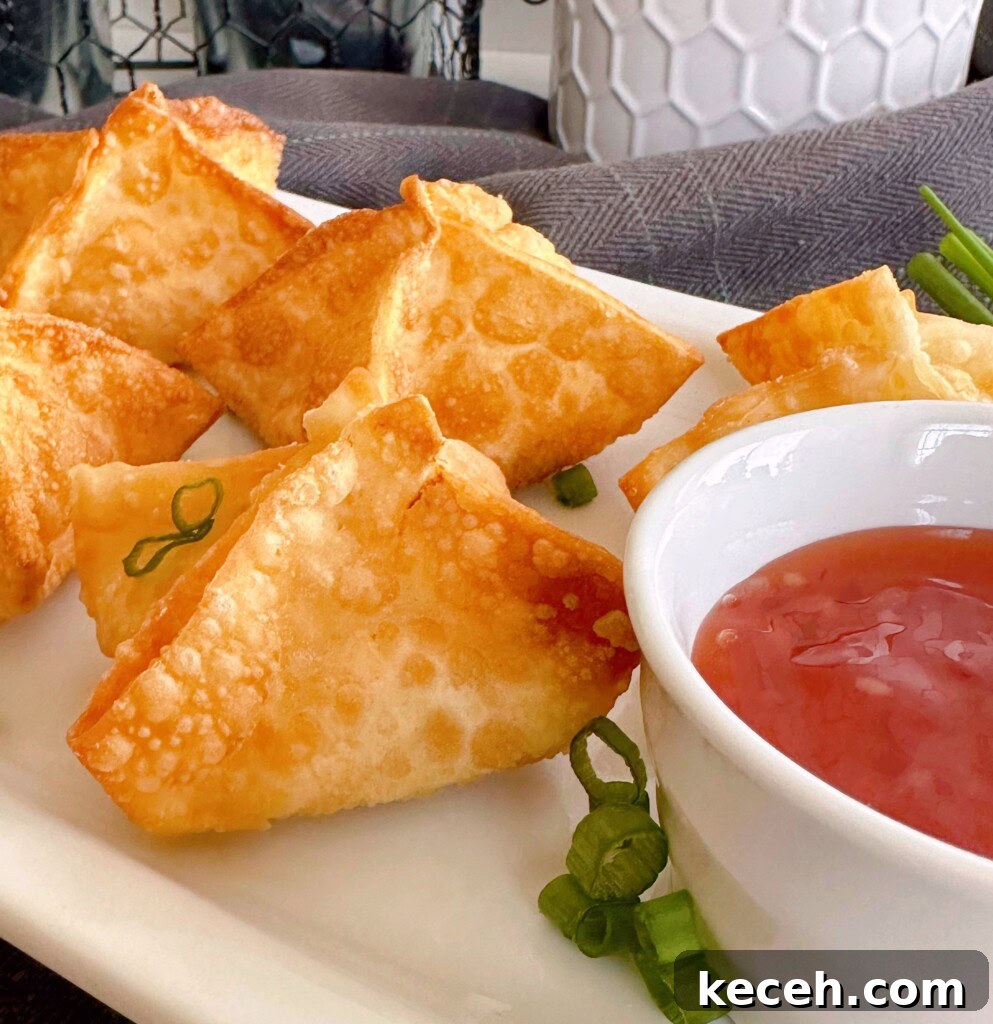 Classic Crab Rangoon Recipe: Crispy Crab & Cream Cheese Wontons 3 Fried cream cheese rangoons on a platter with dipping sauce.
