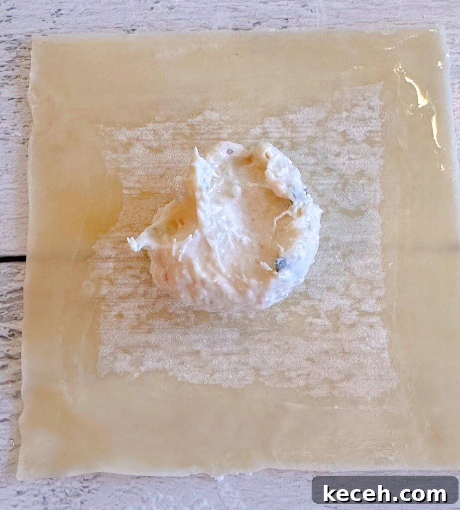 Classic Crab Rangoon Recipe: Crispy Crab & Cream Cheese Wontons 6 Filling placed in the center of the wonton wrapper.