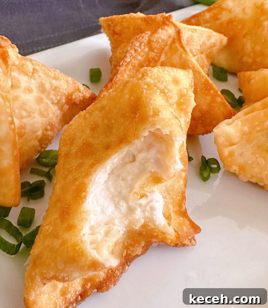 Classic Crab Rangoon Recipe: Crispy Crab & Cream Cheese Wontons 10 One of the wontons bitten into to show cream filling.