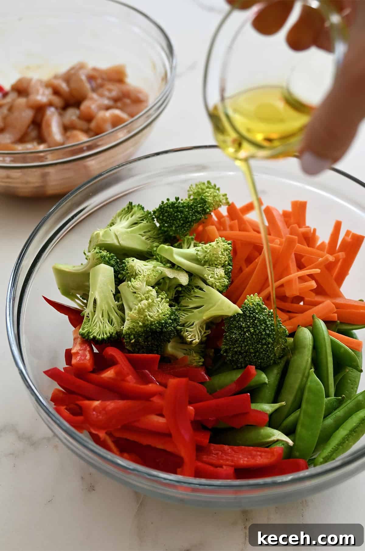 Sheet Pan Teriyaki Chicken with Roasted Vegetables 6 Pouring olive oil over veggies in a bowl.