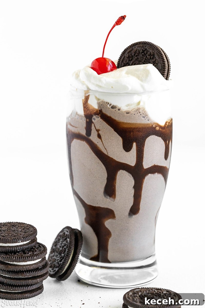 Creamy Oreo Milkshake Recipe for Homemade Dessert 2 Oreo Milkshake in a glass with whipped cream, a cherry on top, and an Oreo.