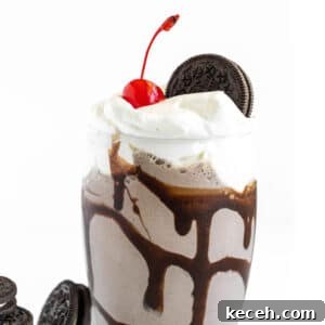 Glass filled with Oreo Milkshake and topped with whipped cream and an Oreo cookie.