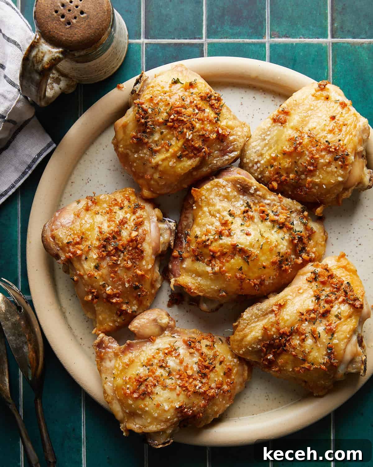 Crispy Baked Garlic Butter Chicken Thighs 8 Overhead image of garlic butter chicken thighs on a plate, coated in rich garlic butter sauce with golden-brown skin and fresh herbs, ready to serve.