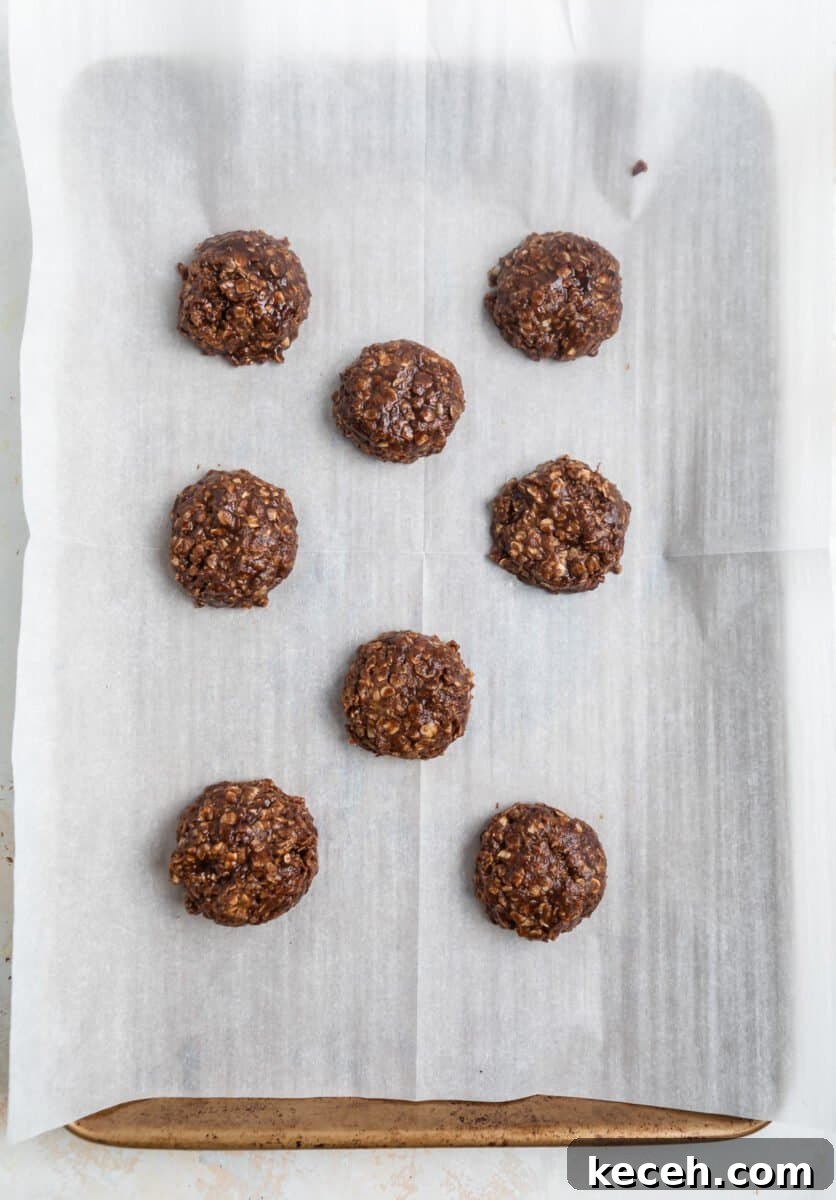 No-Bake Cookie Butter Treats: Quick No-Oven Dessert Recipe 8 Cookie butter cookies spooned on parchment lined cookie sheet.