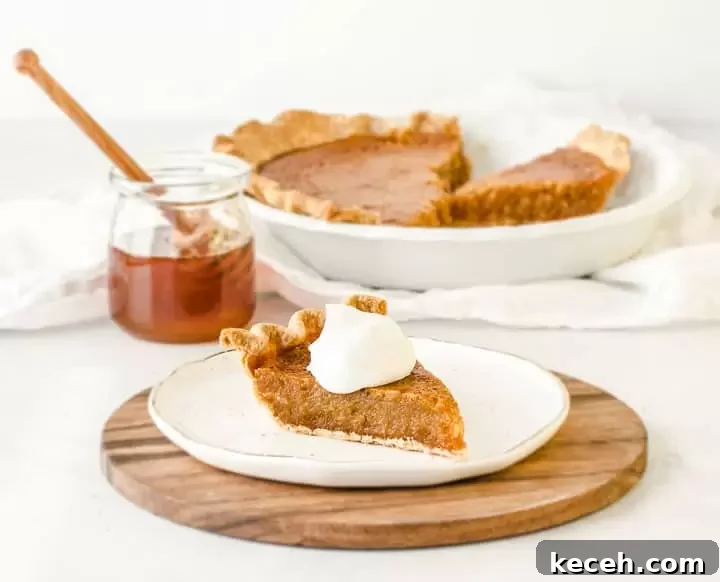 Classic Honey Pie Recipe: Sweet, Buttery Homemade Tart 2 slice of honey pie on a plate with the rest of the pie and a jar of honey in the background