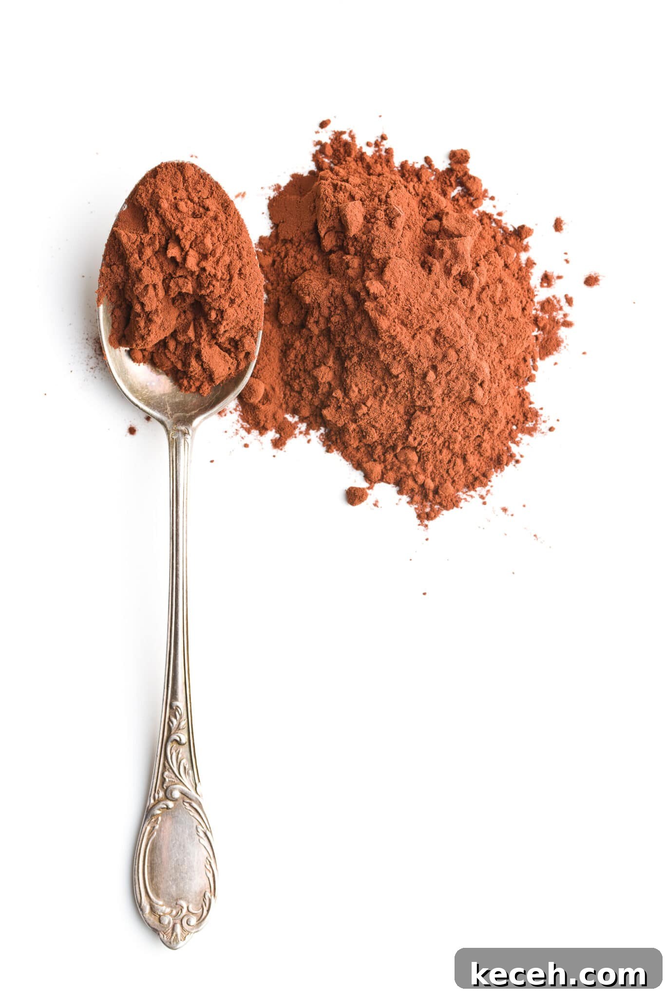 A spoon next to a small pile of cocoa powder.