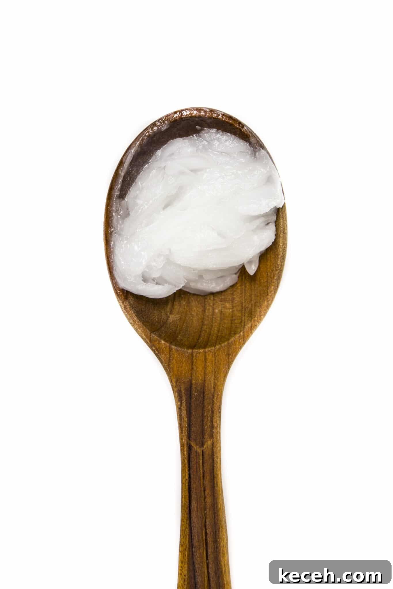 Coconut on a wooden spoon against an isolated white background.
