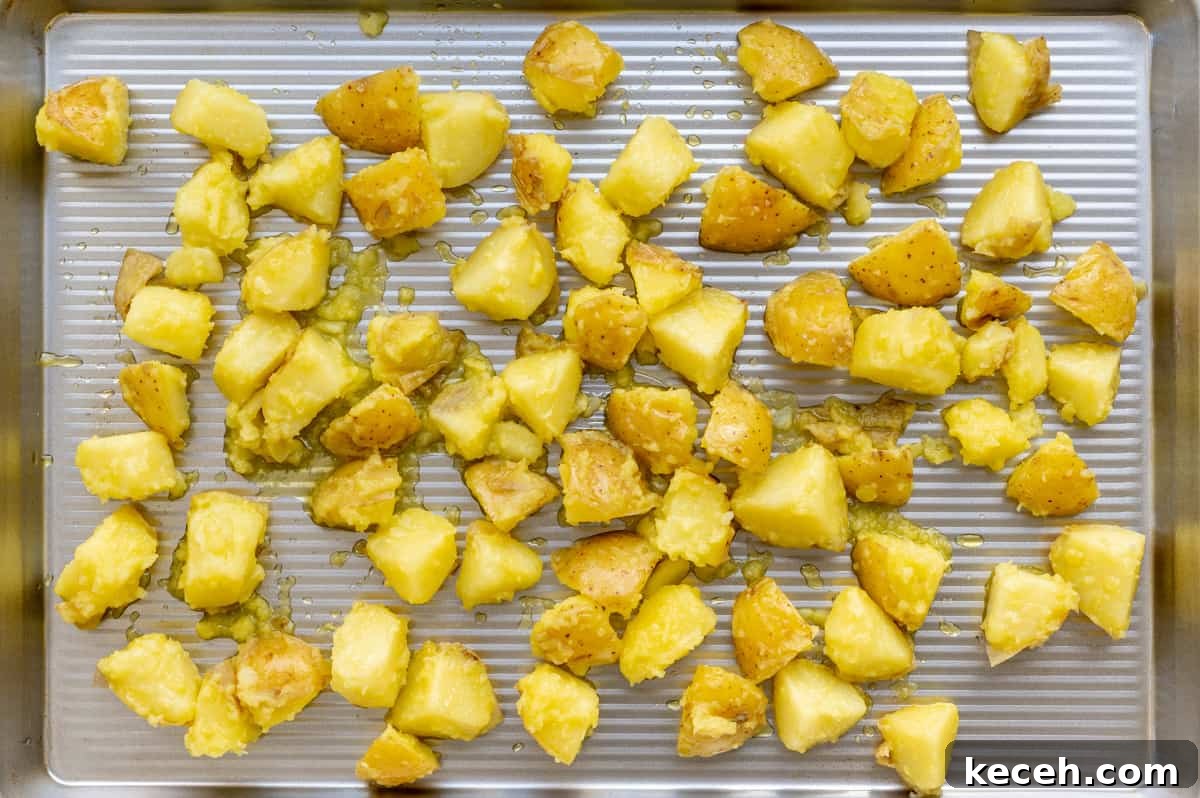 Crispy Rosemary Roasted Potatoes Recipe 8 potatoes on a rimmed baking sheet before roasting.