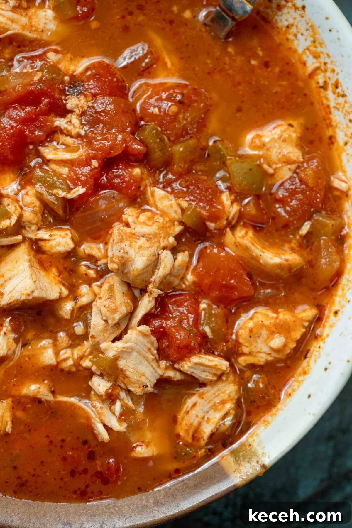 Fiery Chicken Soup Recipe for Bold, Comforting Flavor 4 closeup of a spicy soup full of peppers and juicy shredded chicken