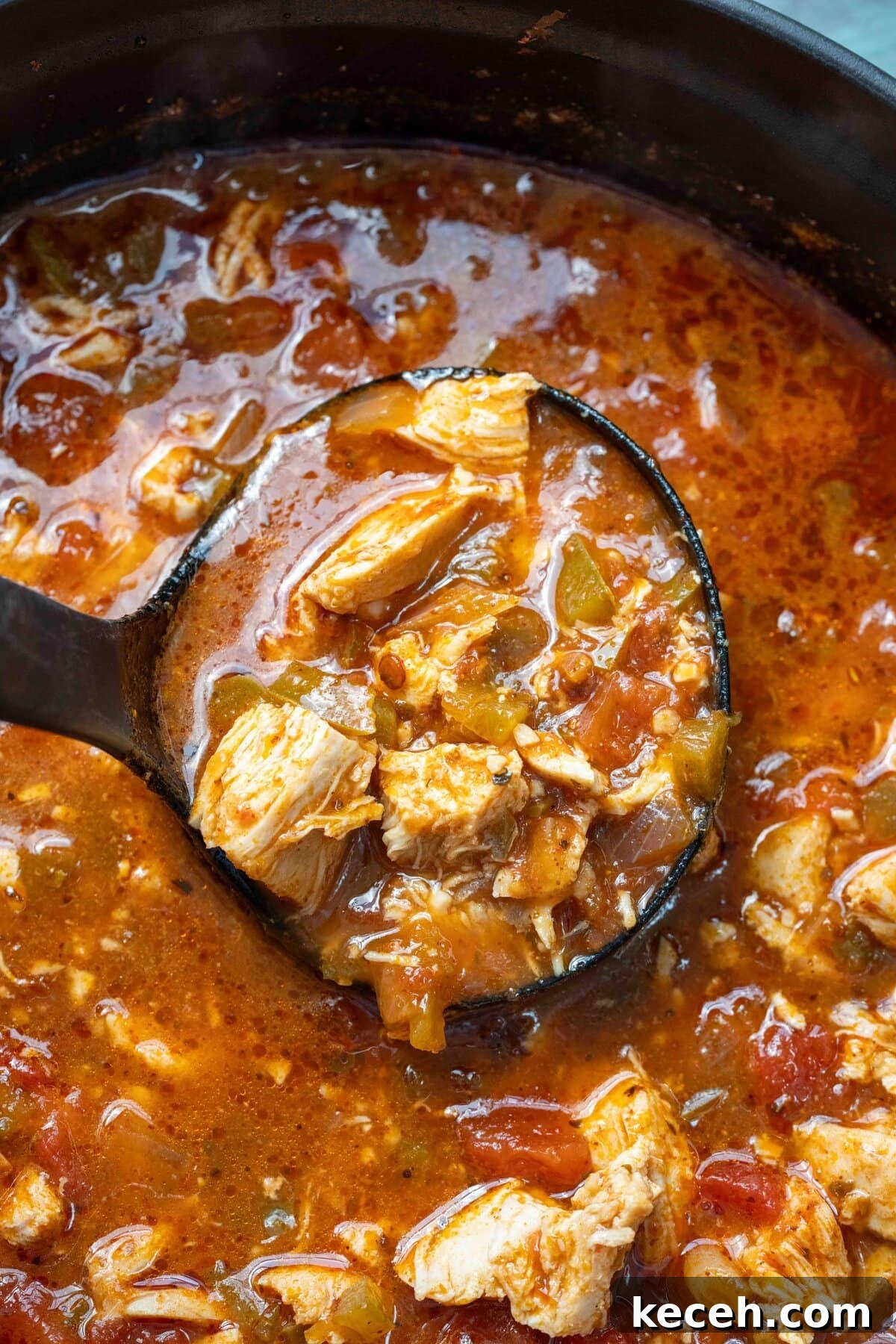 Fiery Chicken Soup Recipe for Bold, Comforting Flavor 10 overhead shot showing a ladle full of spicy soup over a dutch oven full of chicken and pepper soup