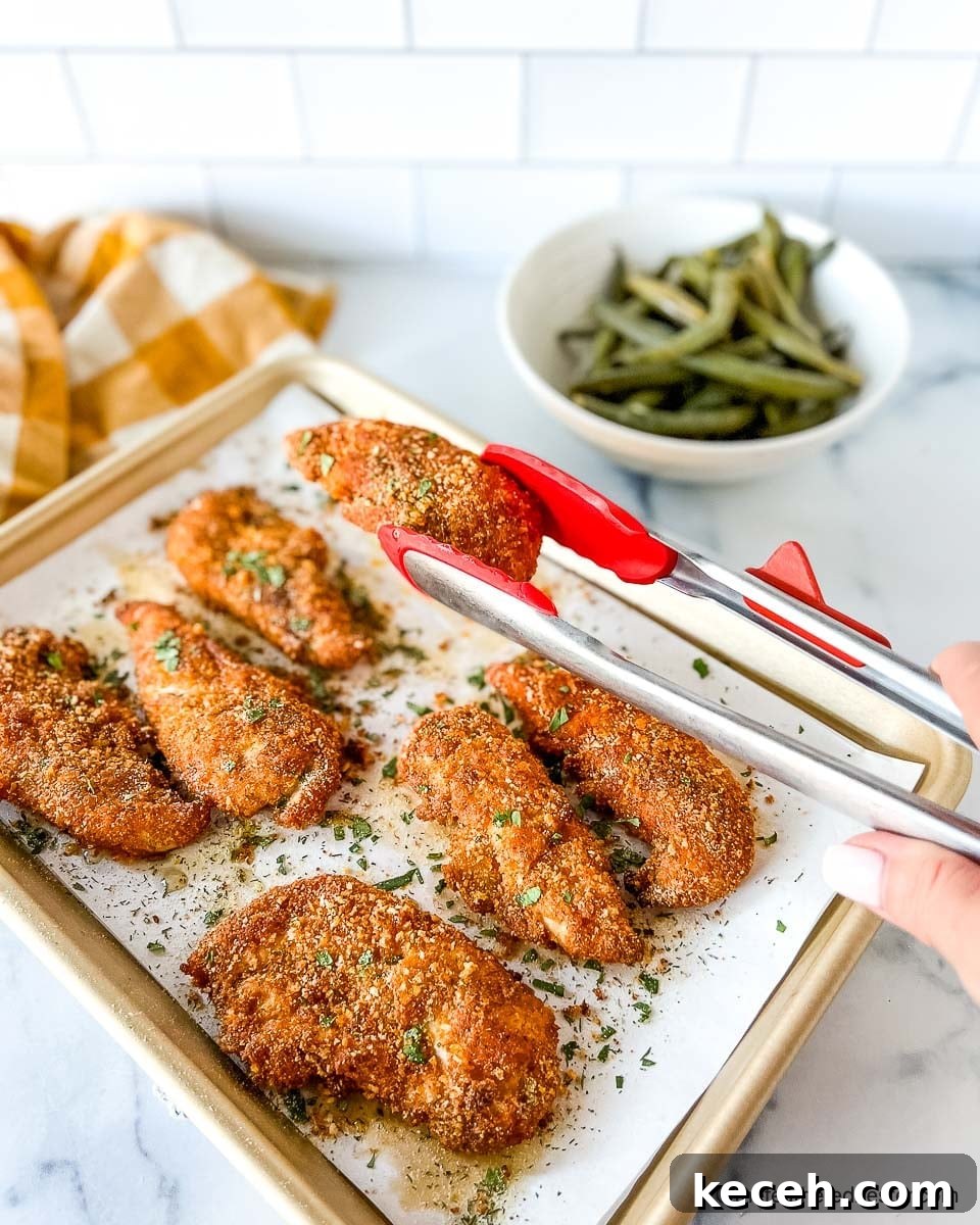 Crispy Shake and Bake Chicken Recipe for Perfect Oven-Fried Crunch 8 Cooked shake and bake chicken tenders on top of a parchment paper lined baking sheet.