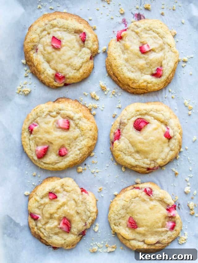 A baking sheet with strawberry cookies on it.