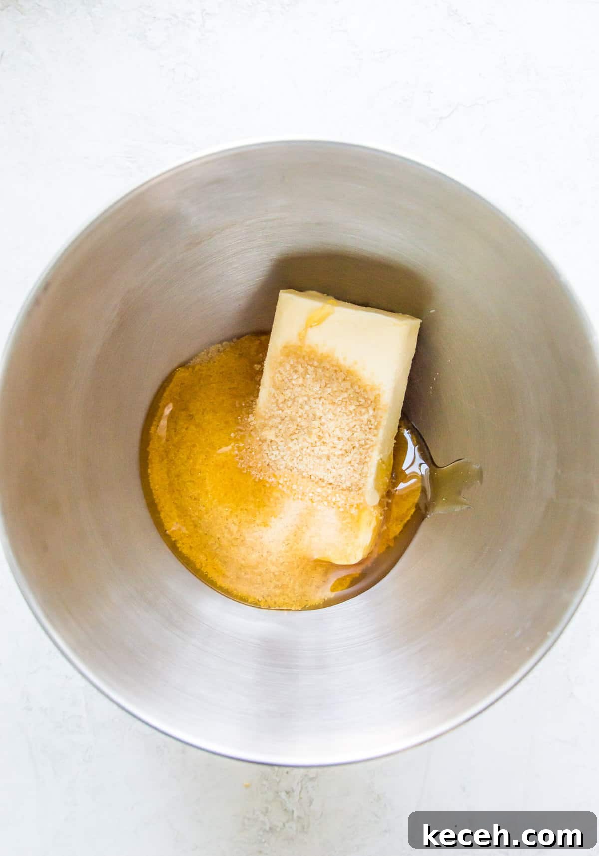 A bowl with a stick of butter and sugar in it.